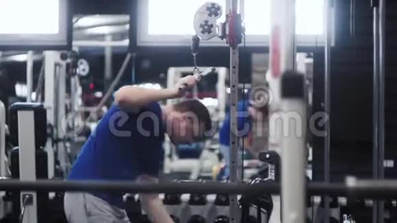 帅哥帅哥在健身房锻炼时拉绳三头肌下推运动视频的预览图
