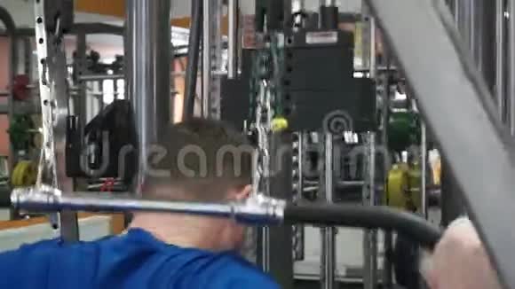 体育运动中的年轻运动员在健身器中的下拉杆锻炼机上进行背部肌肉锻炼视频的预览图