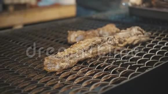在街上的市场上烤鱼街上市场上的鱼烤架上有燃烧的辉光煤新鲜海鲜烧烤视频的预览图