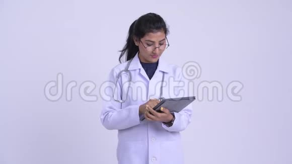 年轻快乐的波斯女医生在用数码平板电脑思考视频的预览图