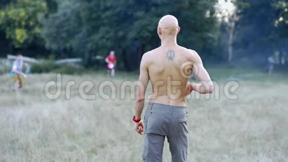 运动缓慢的年轻苗条运动男子裸露的躯干捕捉和投掷飞盘视频的预览图