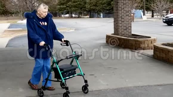 老妇人在停车场外面散步时使用步行器视频的预览图