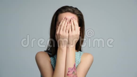快乐的微笑女人玩捉迷藏用手掌捂住脸视频的预览图
