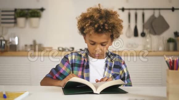 坐在桌子后面看书的男孩视频的预览图