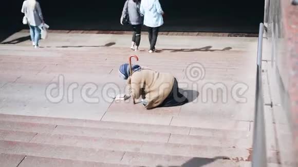 无家可归的乞丐女人在地铁入口处乞讨视频的预览图