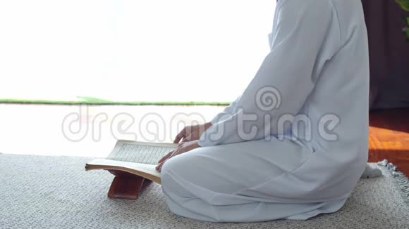 穿着伊斯兰服装读古兰经的穆斯林青年视频的预览图