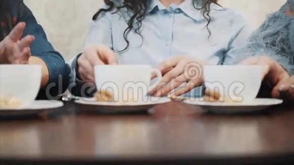 三个好的年轻女朋友在一家咖啡馆相遇同时喝卡布奇诺有长长的黑发视频的预览图