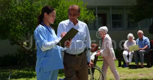 积极的亚洲老年男女医生在花园里讨论医疗报告的正面看法视频的预览图