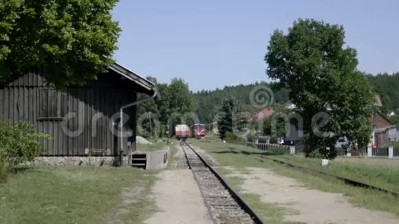 动车客运列车到达火车站红色机车在窄轨道上行驶视频的预览图