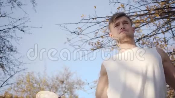 两个成年白人运动员在秋季公园热身强壮的男孩在户外运动前伸展身体健康视频的预览图