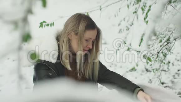 年轻时尚的妈妈和她可爱的女儿在冬天的雪公园视频的预览图