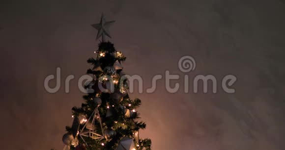 圣诞树上有发光的花环上面装饰着银星和球视频的预览图