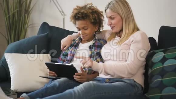 美国妇女和多民族男孩一起坐在沙发上在线观看视频的预览图
