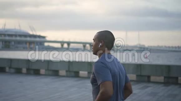 快乐非裔美国人成人职业时尚男士慢跑和耳机听音乐的面部肖像视频的预览图