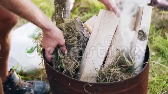 一个人把木头放进桶里放火烧他们快关门烧烤和烧烤视频的预览图