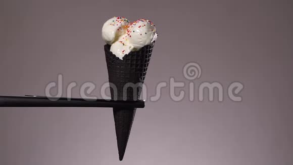 纸屑落在蛋筒里的白色冰淇淋上冰淇淋装饰视频的预览图