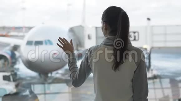 侧视女孩在机场窗口看飞机并画出心脏标志视频的预览图