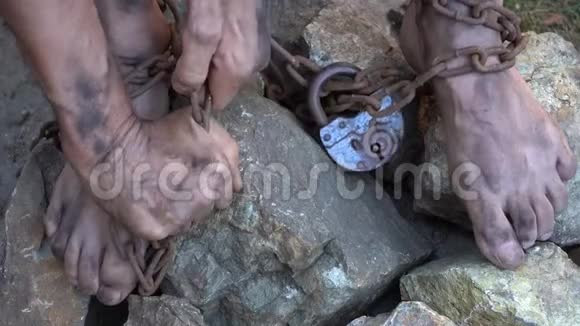 被囚禁的人奴隶的手脚被铁链捆住视频的预览图