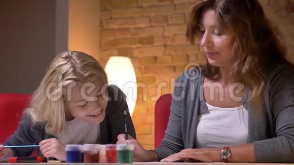 年轻的白种人母亲和她漂亮的小女儿在一起的特写镜头女孩观察她妈妈视频的预览图