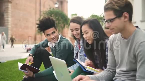 快乐的多种族美国朋友在放学后一起工作一起谈论大学用电话和视频的预览图