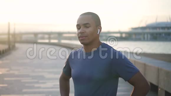 快乐非裔美国人成人混合种族运动员模型训练和智能技术跑步的面部肖像视频的预览图
