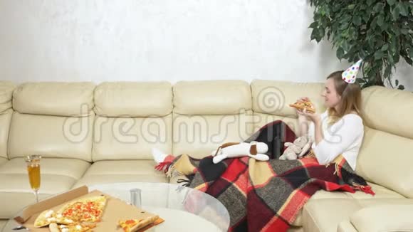 孤独的女人在软玩具的陪伴下在沙发上喝酒视频的预览图