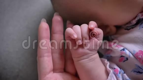 特写镜头的妈妈和可爱的新生宝宝手相触视频的预览图