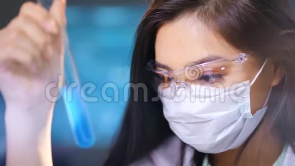 位戴眼镜戴面罩的女医务技术人员在实验室制作药剂视频的预览图