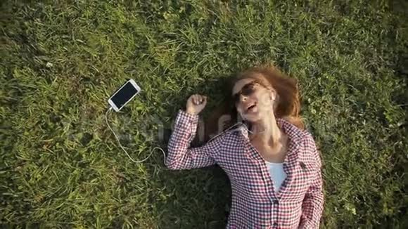 女孩在草地上快乐地唱歌视频的预览图
