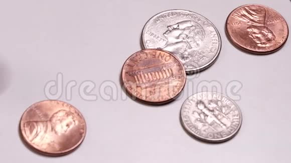不同的美国硬币在框架内旋转和停止特写镜头美国小型金属现金在一张白色的桌子上移动这就是视频的预览图