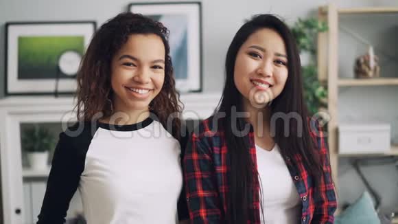 慢镜头描绘好看的女孩混血朋友非裔美国人和亚洲人看着相机和微笑视频的预览图