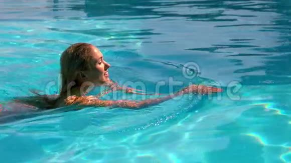 金发女郎游过游泳池视频的预览图