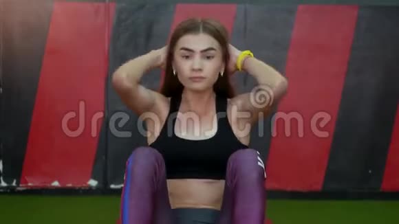 美丽的肌肉女人在健身房做木板锻炼来提高她的腹肌年轻女孩做腹肌练习要有一个扁平的视频的预览图