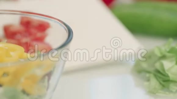 透明碗里的新鲜蔬菜沙拉准备沙拉的特写镜头视频的预览图
