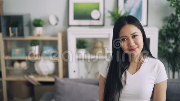 可爱的亚洲女士的慢镜头肖像微笑着站在漂亮的房间里微笑着看着摄像机视频的预览图