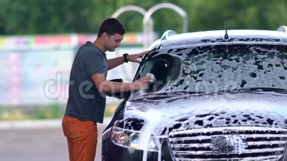 年轻人在他的车上洗挡风玻璃视频的预览图