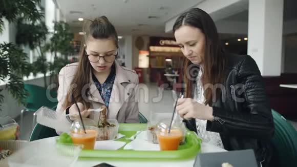 母女俩是一个十几岁的孩子在咖啡馆里吃面条说话视频的预览图