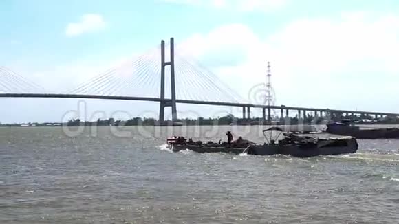 这艘小船或驳船在新建成的巨大斜拉桥河流中滑行视频的预览图