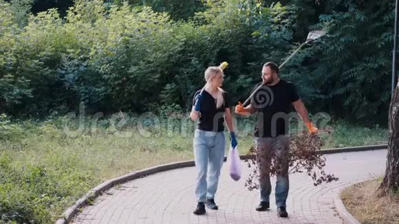 两名志愿者在清理一个当地公园后拿出垃圾和干树枝视频的预览图
