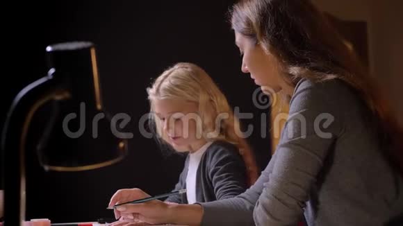 年轻的白种人母亲帮她的小可爱女儿拍摄的特写镜头背景是黑人视频的预览图