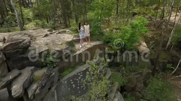 两个穿着短裙的美女站在岩石地上的俯视图可爱的女朋友度过周末视频的预览图