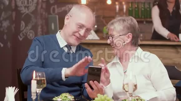 一对老夫妇在约会时和他们的孩子视频通话视频的预览图