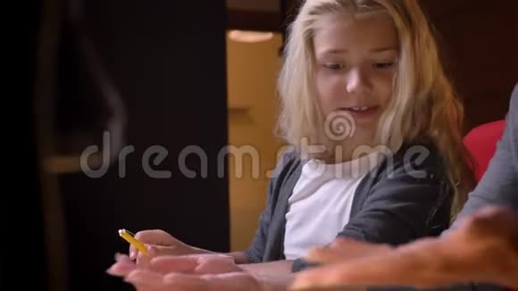 小漂亮女学生的特写镜头掩盖了她的家庭作业和兴奋与背景隔离在黑色视频的预览图