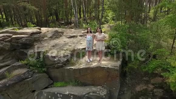 两个穿着短裙的美女站在岩石地上的俯视图可爱的女朋友度过周末视频的预览图