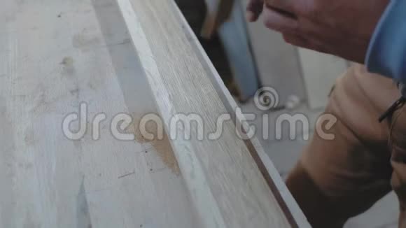 木匠用一个角度测量一个正方形的木板用铅笔标出尺寸4k4k录像慢动作视频的预览图