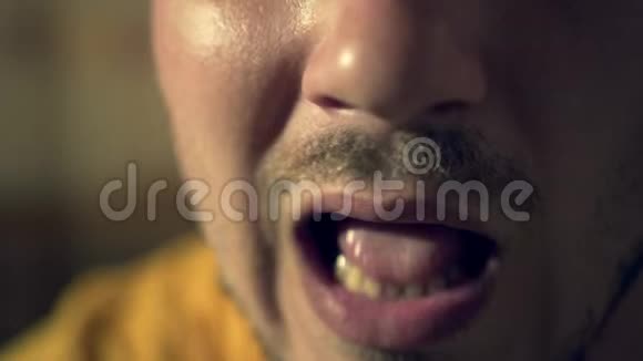 一个年轻人的轮廓特写的嘴有刚毛男性口咬和咀嚼酸奶或酸奶油视频的预览图