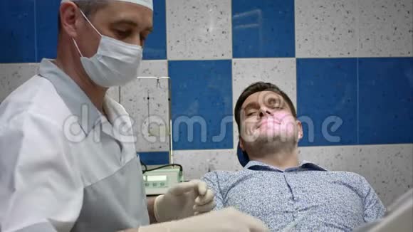 男性牙医检查其男性客户的牙齿视频的预览图