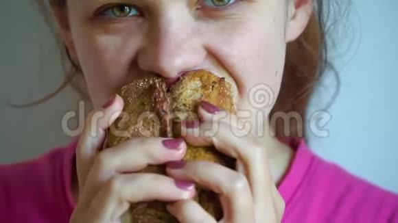 年轻女子在咖啡馆里愉快地吃快餐三明治慢动作视频的预览图