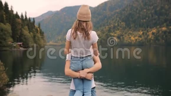 在大自然的第一次约会中一对美丽的快乐的浪漫的男女拥抱在一起围着圆圈玩微笑着或视频的预览图