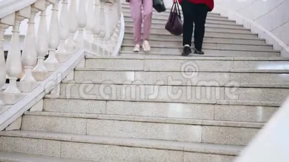 两个女人下了商场的楼梯腿的特写视频的预览图